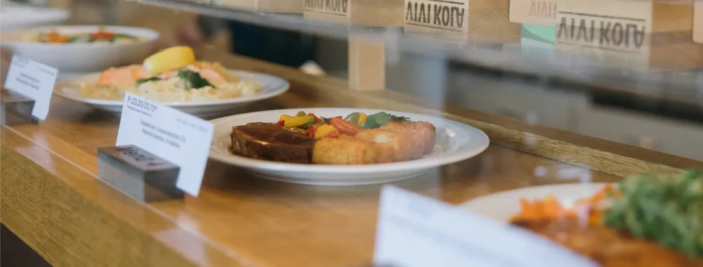 Teller mit Fleisch und buntem Gemüse auf einem Restauranttisch