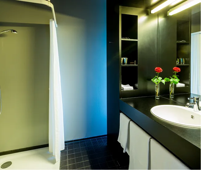 Modernes Hotelbadezimmer mit Waschtisch und blauer Beleuchtung