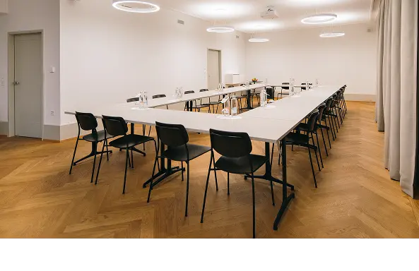 Vorbereiteter Seminarraum mit Tischreihen für Veranstaltungen