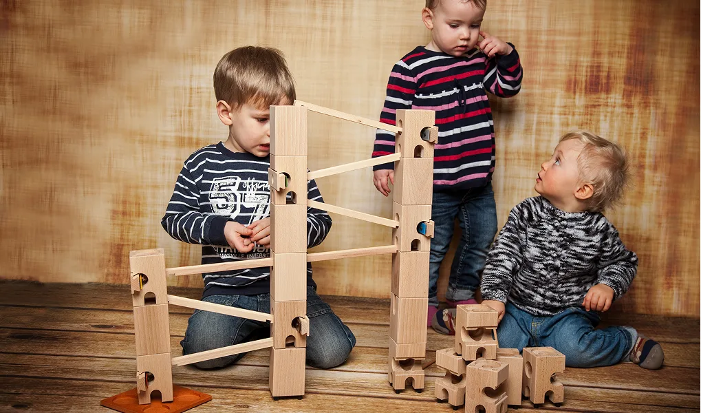 Kinder spielen mit der Xyloba-Holzkugelbahn