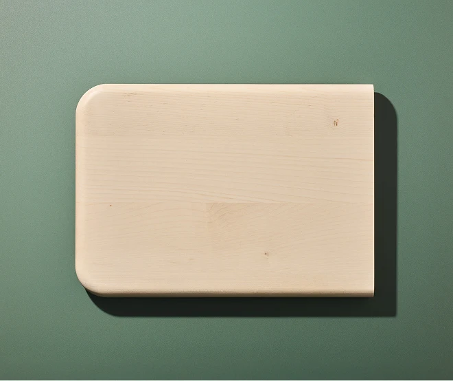 Servierbrett aus Holz an einer dunkelgrünen Wand