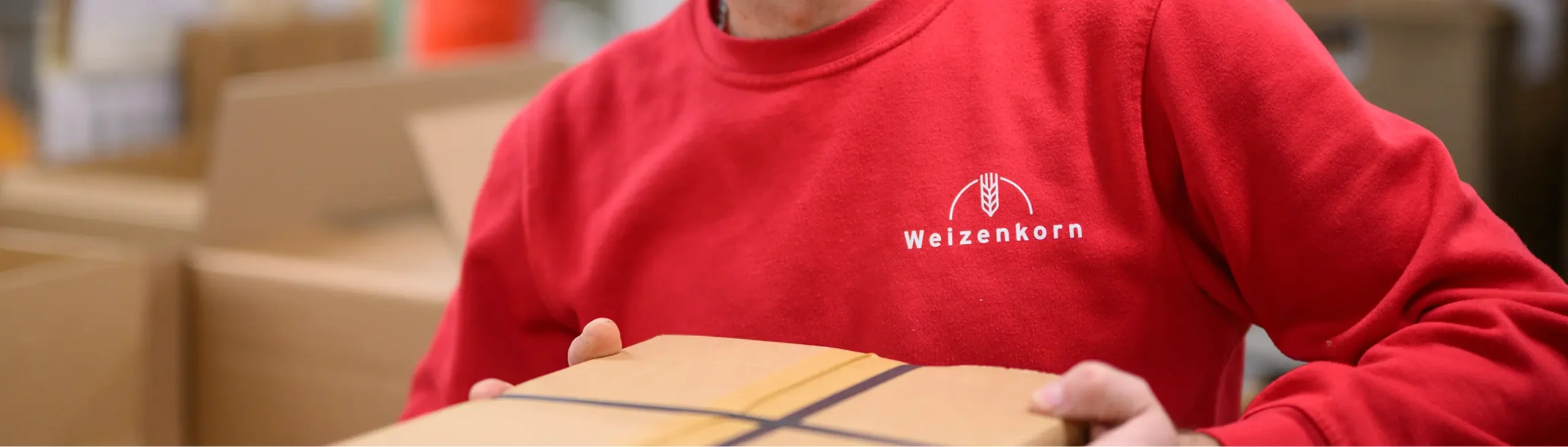 Nahaufnahme einer Person im roten Weizenkorn-Pullover, die an einem Holzobjekt arbeitet