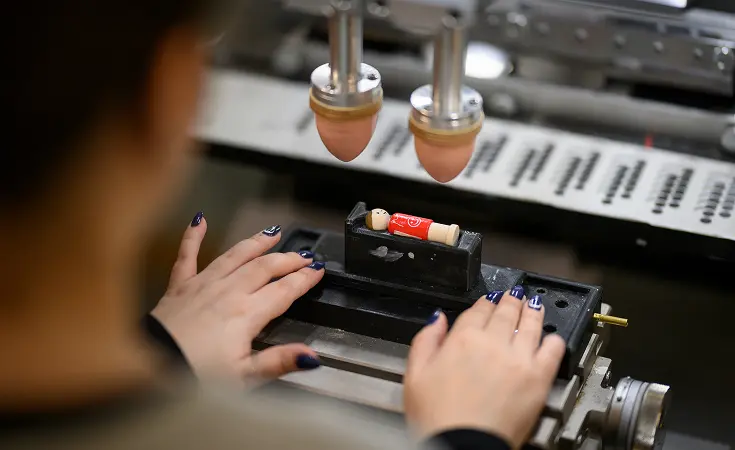 Nahaufnahme von Händen, die an einem elektronischen Gerät mit Tasten arbeiten